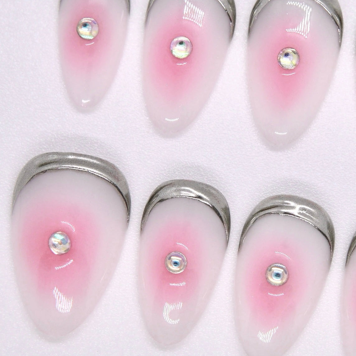 Side view of glossy press-on nails with pink-white fade and soft shimmer