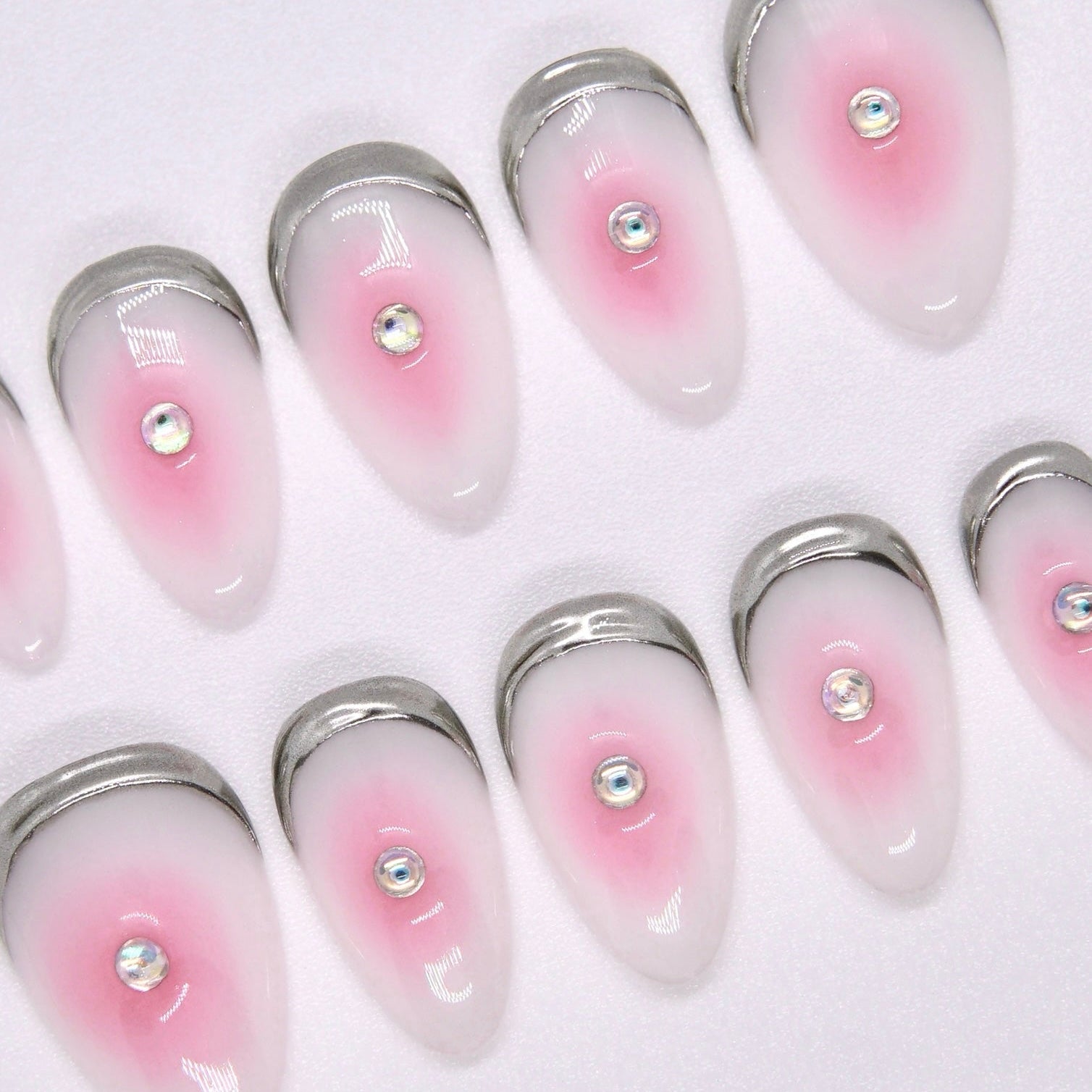 Close-up of pink jelly ombré nails with dewy finish and rhinestone detail
