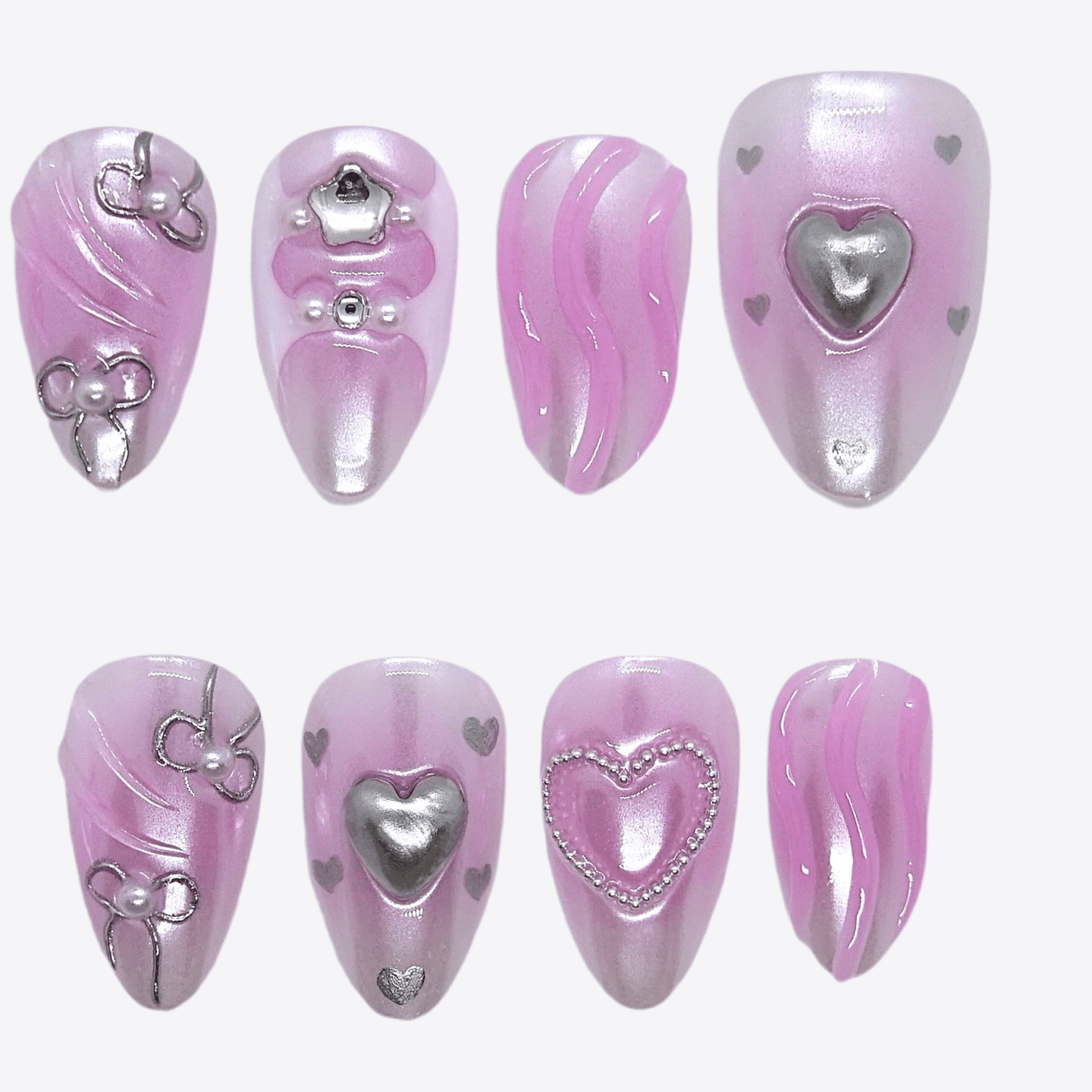 Close-up of metallic heart embellishment on pink press-on nails with curved 3D design