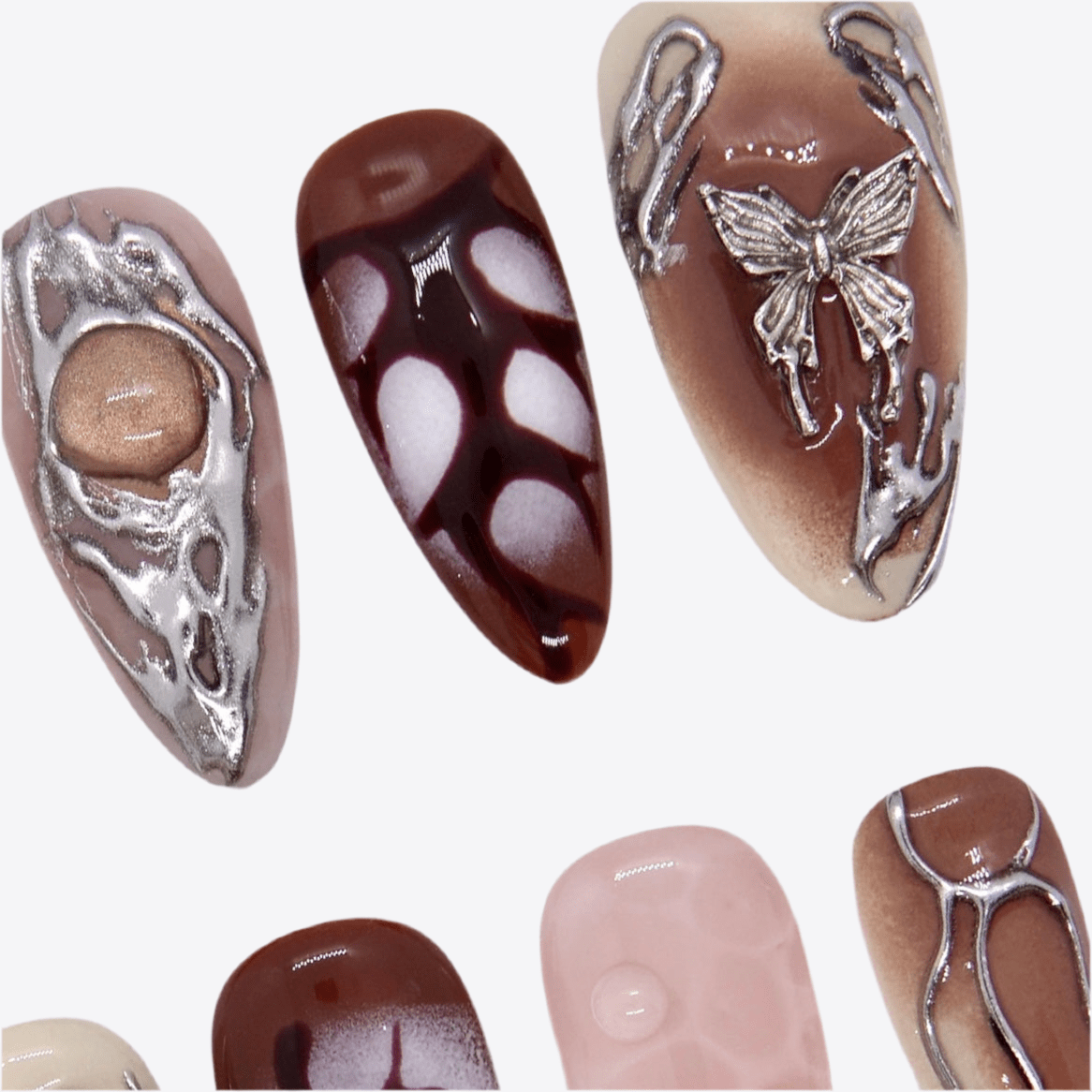 Close-up of brown and nude press-on nails featuring metallic overlays and relic texture.