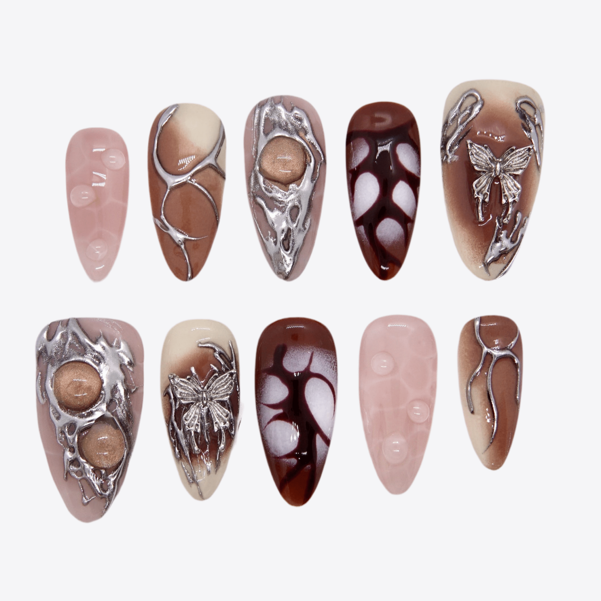 Press-on nails in earth tones with silver sculptural accents and butterfly motifs.