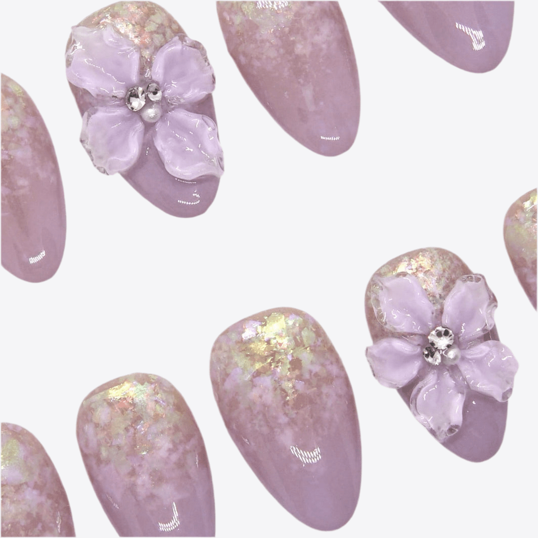 Close-up of 3D floral accent with subtle shimmer on lavender ombré press-on nails.