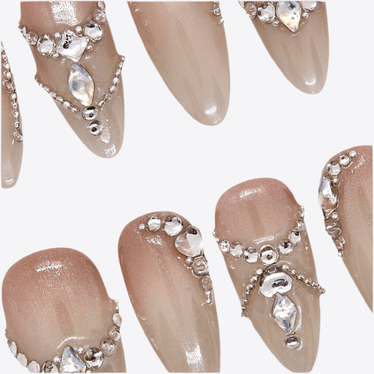 Close-up of crystal accents on glossy nude press-on nails